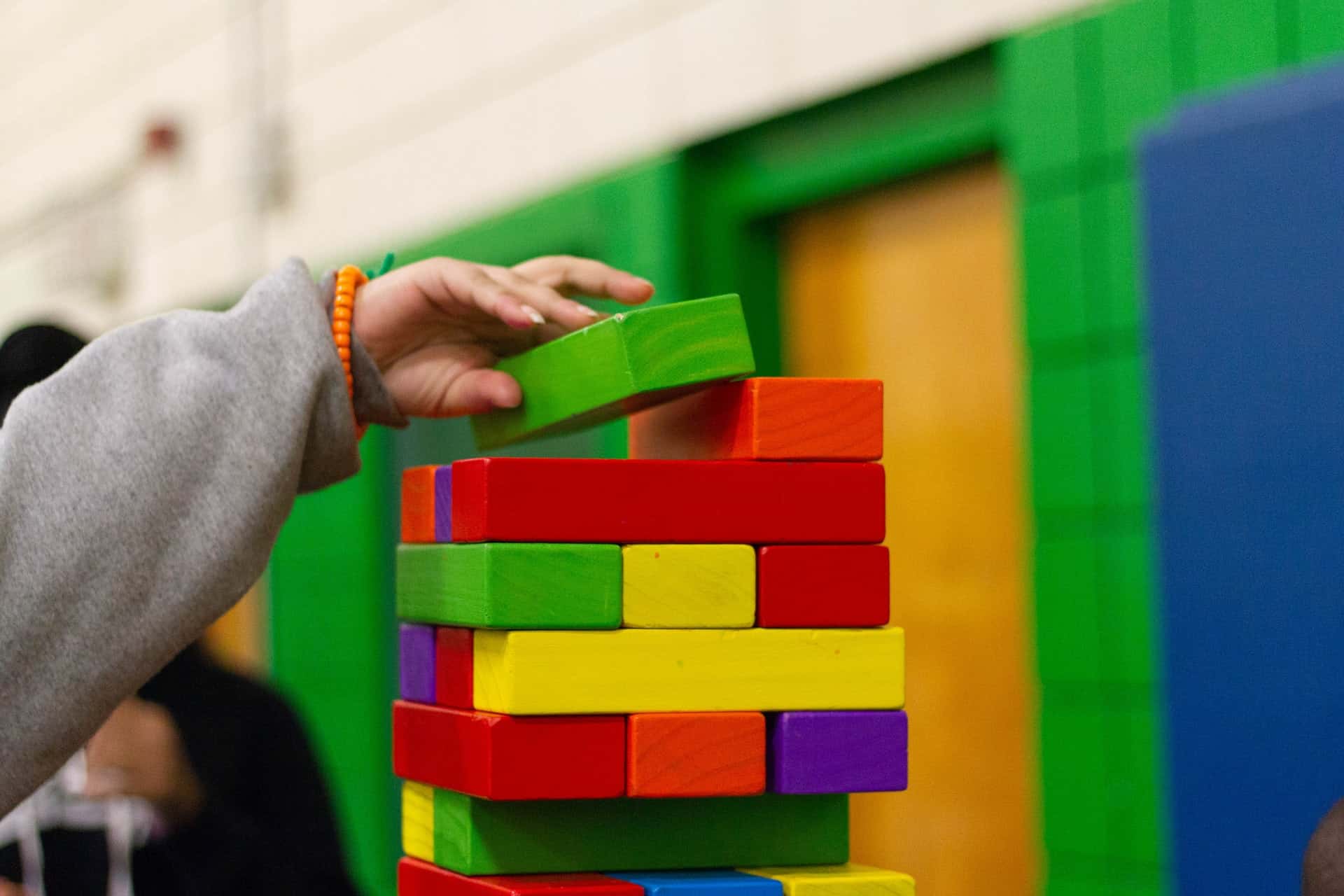 Lapsi tekee tornia eri värisistä rakennuspalikoista.